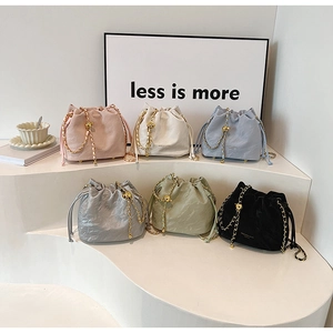 Detail view of drawstring bucket bags in six colors with gold chain straps and metal beads