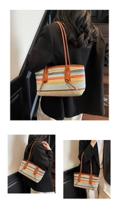 Detail of colorful woven tote bag featuring striped texture and knotted leather handles