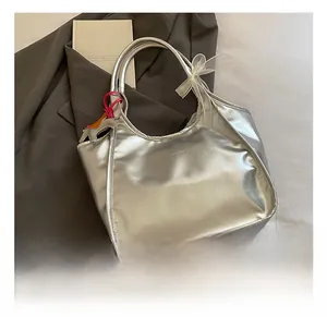 Detail of silver tote bag featuring a white organza bow and a cute puppy charm accessory