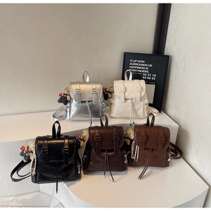 Présentation de sacs à dos en simili cuir en cinq couleurs avec breloque d'ours