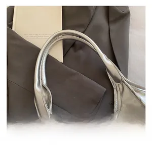 Detail showing the wide integrated handle and metallic silver oil wax leather texture