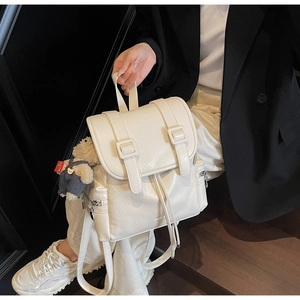 Vue détaillée du sac à dos en similicuir blanc cassé avec cordon et fermoir à boucle