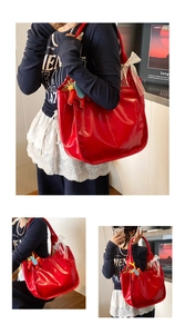 Detail of red glossy tote bag with mesh bow and leather horse charm accessory