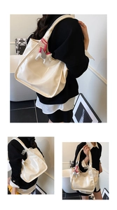 Close-up of cream oil-wax leather tote bag showing glossy texture and Pegasus charm detail