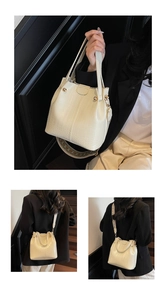 Detail of cream crocodile embossed bucket bag with wide ethnic geometric strap
