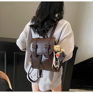 Vue détaillée du dos d'un sac à dos vintage en similicuir marron foncé avec ours peluche