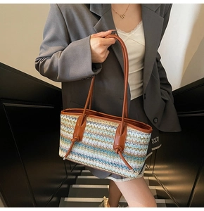 Detail of bohemian woven tote bag showing colorful zigzag texture and leather knot handles