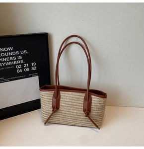 Close-up of woven straw texture with brown leather shoulder strap and decorative knot detail
