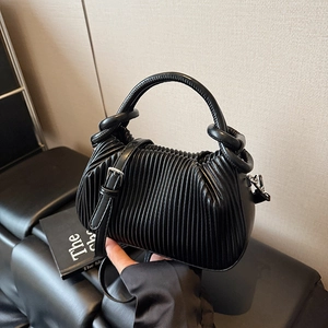 Close-up of the black pleated texture and silver metallic hardware on the handbag