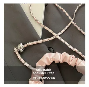 Detail of pink pleated strap with silver ball adjuster and chain for shoulder bag