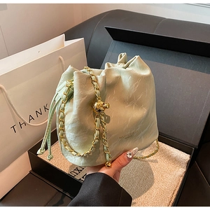 Detail of mint green marble pattern bucket bag with gold chain and drawstring closure