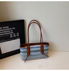 Detail of the multi-colored woven pattern and brown leather handle on this tote bag