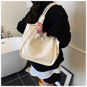 Close-up of cream wax leather tote bag with a horse charm in a modern minimalist setting