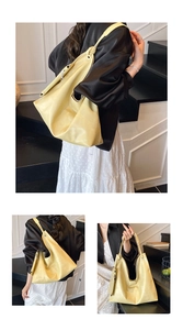 Detail of cream leather bucket bag with knot handle and functional side zipper pocket