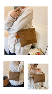 Détail du sac enveloppe en paille tressée avec motifs circulaires et pompon décoratif