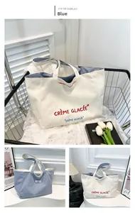Détail du sac cabas réversible en toile avec lettrage artistique et texture à rayures bleues