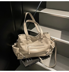 Detail view of cream oversized PU leather tote featuring multi-pockets and silver hardware