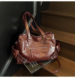 Detailed side view of a vintage dark red tote bag featuring side pockets and zippers