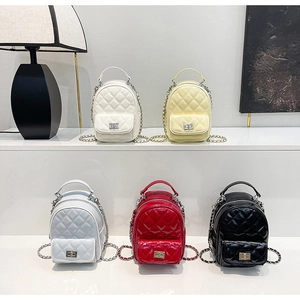 Detailed close-up of colorful quilted patent leather mini backpacks with metal chain straps