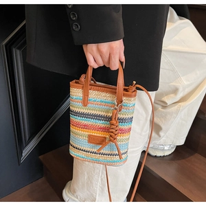 Detail of colorful striped woven raffia bag with premium brown leather handles and strap