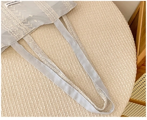 Nahaufnahme der hellblauen Stofftasche mit weißen geometrischen Stickmustern