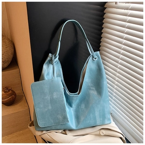 Close-up of sky blue faux leather tote bag with a matching small clutch and matte texture