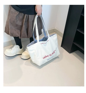 Détail du grand sac cabas en toile blanche montrant la doublure intérieure à rayures bleues