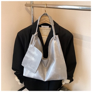 Detail of silver tote bag set with matching small zipper pouch on black blazer