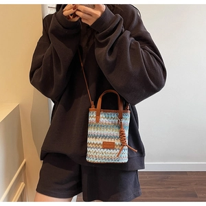Detail of multi-color woven pattern on mini crossbody bag with leather brand patch