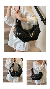 Detailed view of black glossy patent leather shoulder bag with chic pleated design and bear charm