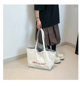 Détail du sac cabas en toile blanche avec texte français et doublure intérieure rayée