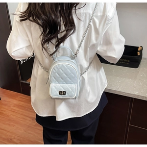 Close-up of quilted light blue mini backpack featuring elegant silver chain straps and turn-lock