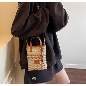 Detail of colorful wavy woven crossbody bag with brown leather fringe and shoulder strap