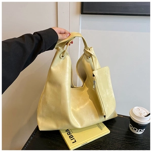 Detail of light yellow faux leather tote bag with matching detachable zipper pouch