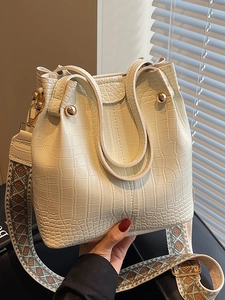 Chic beige crocodile pattern bucket bag with wide jacquard strap and gold studs