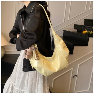 Hobo shoulder bag with retro pleats and cute brown plush bear charm in a chic interior