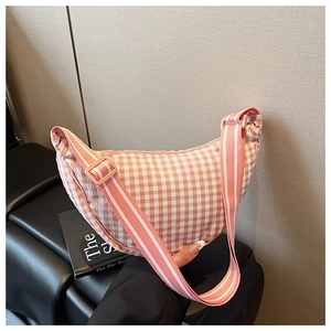 Detail of pink and white checkered crescent bag with adjustable striped strap and zipper