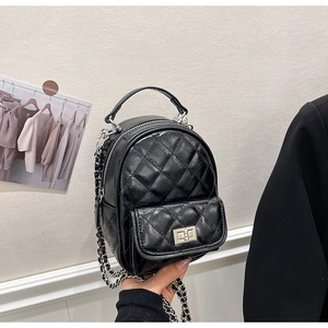 Close-up of black quilted leather mini backpack with silver metal chain and twist lock