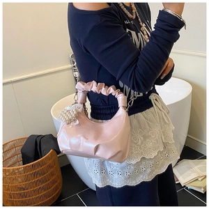 Pink glossy dumpling bag with ruched handle and pearl bow detail for women