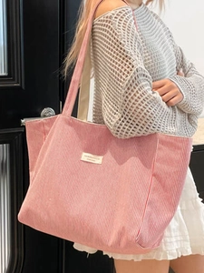 Grand sac cabas en toile à rayures rouges et blanches porté par un mannequin en ville