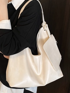 Chic off-white large capacity tote bag with matching pouch on a black blazer
