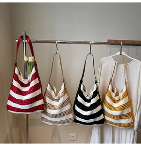 Détail de quatre sacs cabas en tricot à rayures colorées suspendus pour l'été et la plage