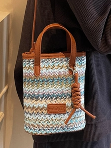 Colorful striped woven shoulder bag with brown leather handles and zigzag pattern