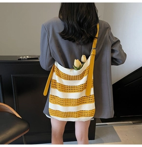Détail de la texture en maille ajourée du sac rayé jaune avec sangle en cuir