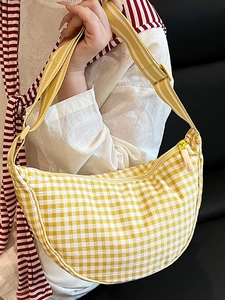 Minimalist yellow checkered crescent bag with adjustable wide strap shown on model