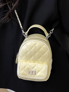 Quilted beige mini backpack with silver chain strap shown on a black suit jacket