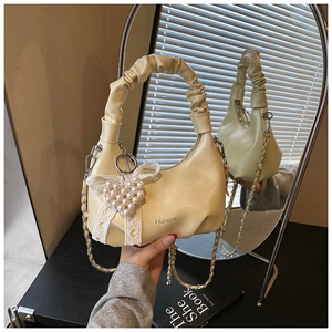 Detail of cream pleated cloud bag with heart pearl charm and detachable chain strap