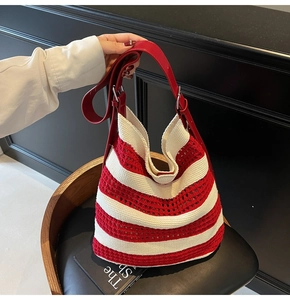Détail du sac fourre-tout tricoté rayé rouge et blanc avec anse en cuir et maille