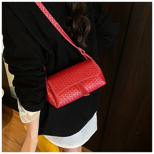 Detail of red woven leather shoulder bag showing the intricate texture and crossbody strap