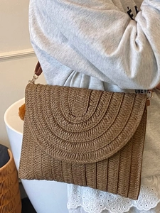 Sac à bandoulière en paille marron pour la plage avec texture tissée et petit pendentif